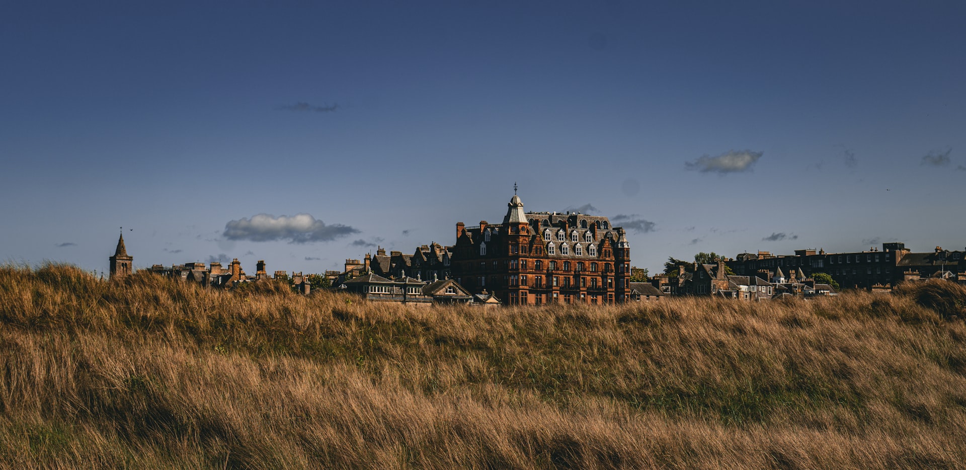 a tall building sitting on top of a lush green field